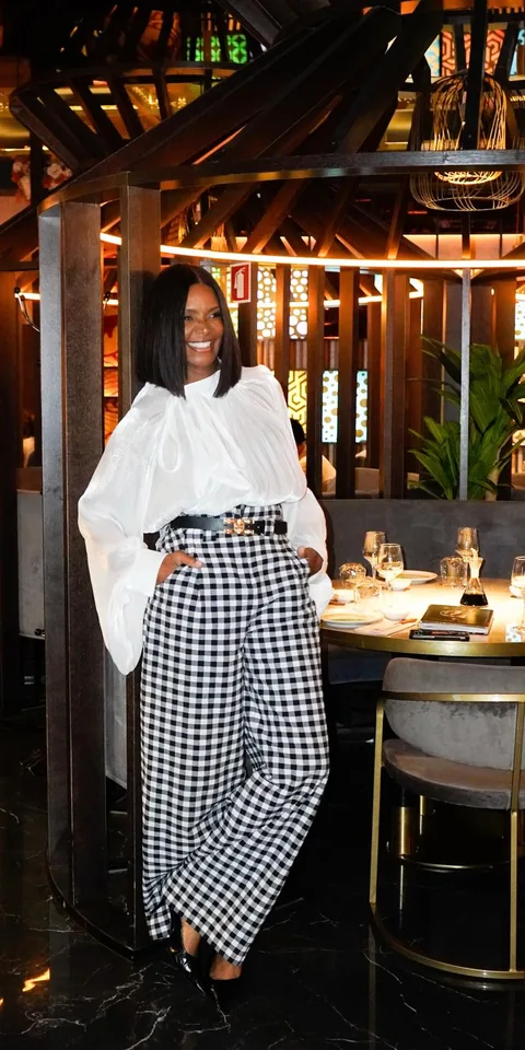 In a white blouse and checked trousers, in a restaurant