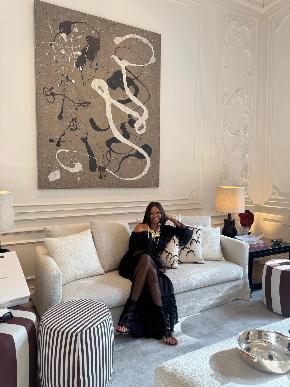 Henriqueta Paredes sentada num sofá, numa sala clara com um quadro grande, consultora de imóveis em Lisboa